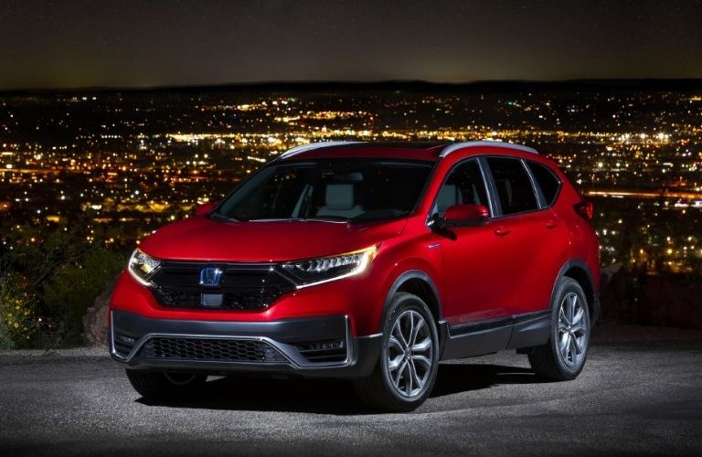 2022 Honda CR-V Hybrid Red parked with a city view at night